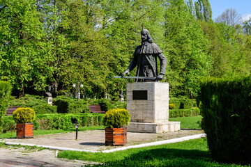 Landscape with vivid green trees and grass in Chindia Park (Parcul Chindia) from Targoviste city in Romania in a sunny spring  day with white clouds and blue sky