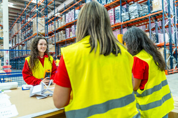 Fototapeta premium Female factory workers pack packages for delivery