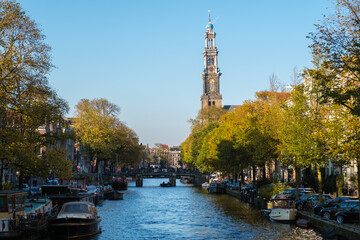 Naklejka premium Autumn vibes along the serene canals of Amsterdam, showcasing the beauty of a crisp blue sky