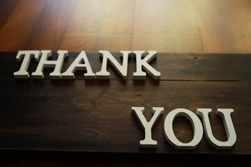 Wooden Sign with "Thank You" Message in White Letters on Dark Wood Background