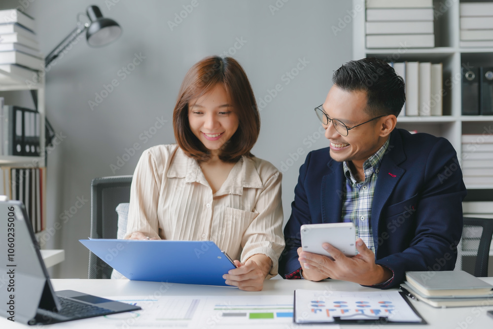 Aufkleber two asian business partners are smiling while analyzing financial data on a tablet and documents in 