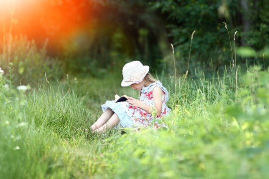 girl reading bible book outdoors