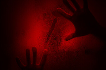 Horror scene of a hands against wet shower glass. Two hands pressing against glass wall indoors....
