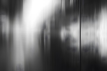 Abstract black and white image with blurred vertical lines and light reflections.