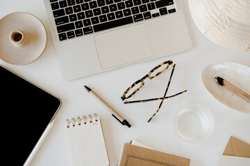 Modern Office Essentials. Laptop, Pen, Notebook, and Glasses Arranged on a White Desk. Efficiency and Style