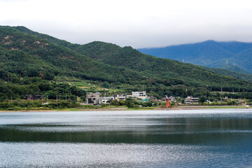 Scenic Lakeside Village Nestled in Lush Green Mountains with Calm Water