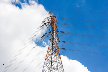 High voltage transmission tower on blue sky background