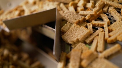 Industrial manufacturing process of croutons moving on conveyor belt