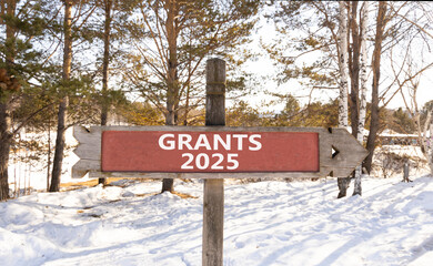 Planning grants 2025 new year symbol. Concept words Grants 2025 on beautiful wooden old retro vintage road sign. Beautiful winter forest background. Business grants 2025 new year concept. Copy space.