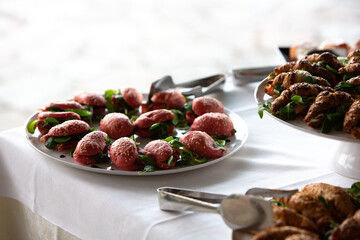 Catering service presenting red beetroot buns and croissants at a banquet table