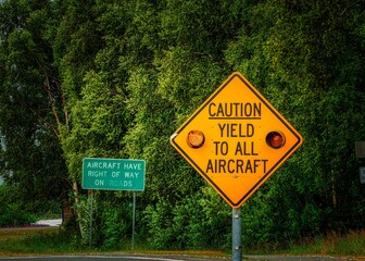 Yellow caution sign warns drivers to yield to all aircraft.