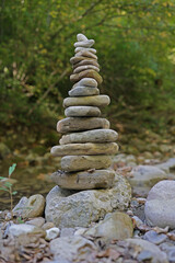 Fototapeta premium Zen stone pyramid on rocky bank of mountain river. Concept Peace Balance Meditation Yoga Life. Spa Banner Image