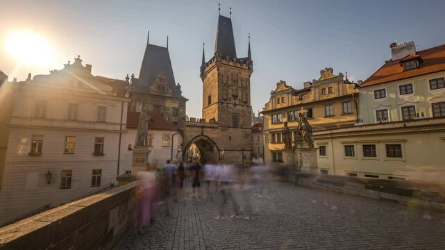 Prague sunset. A view along Charles Bridge in Prague towards the Lesser Quarter in the early morning timelapse hyperlapse. Lots of people can be seen. PRAGUE, CZECH REPUBLIC   