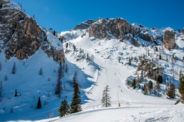 Arabba ski resort in Domites in Italy with beautiful rocks, snow and skiers on ski runs from Porta...