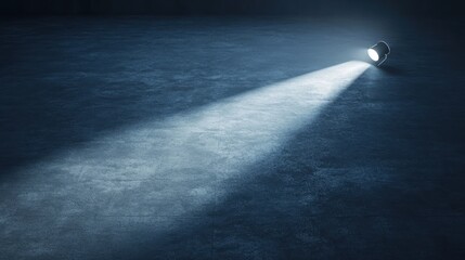 A spotlight illuminates a dark, textured floor, creating a dramatic visual effect.