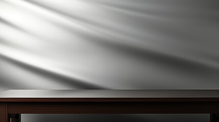 A minimalist scene featuring a wooden table against a softly lit, textured gray wall.