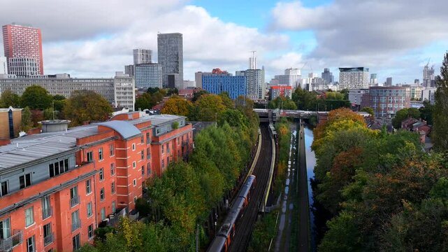 Aerial video of a train traveling towards Birmingham new street station and the city skyline. 
