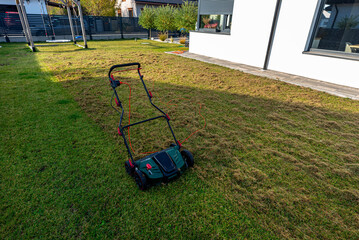 Scarifying the lawn before the winter season using an electric scarifier.