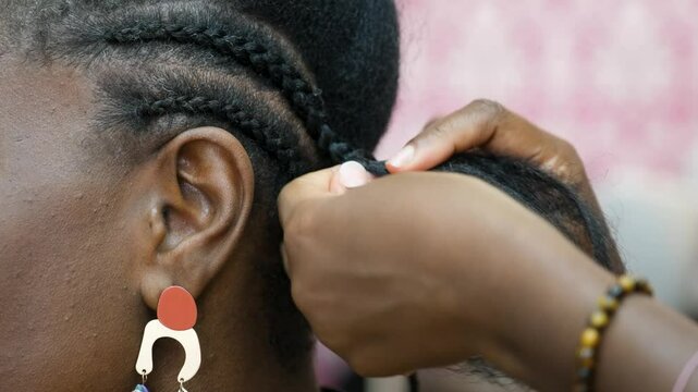Hairdresser creating crochet braids for her customer with afro hair in a hair salon