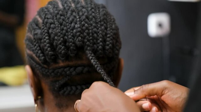 Hairdresser making crochet braids to a client in an afro hair salon