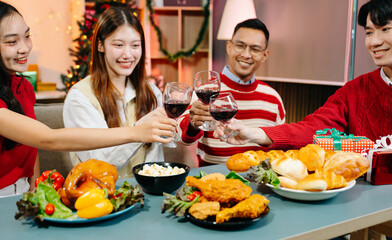 Asian friends capture the holiday spirit with gifts, laughter, and a festive Christmas dinner in a cozy, joy-filled setting