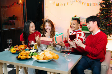 Holiday spirit with Asian friends exchanging gifts, sharing laughs, and enjoying a festive Christmas dinner
