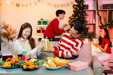 Holiday spirit with Asian friends exchanging gifts, sharing laughs, and enjoying a festive Christmas dinner