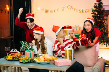 Asian friends capture the holiday spirit with gifts, laughter, and a festive Christmas dinner in a cozy, joy-filled setting