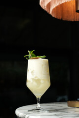 Pina colada cocktail with dry lemon slice and peppermint leaves