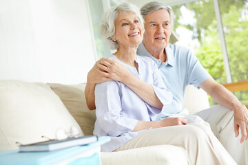 Obraz premium Hug, love and watching tv with senior couple on sofa in living room of home for subscription service. Relax, smile or wellness with happy old man and woman in apartment for entertainment or streaming