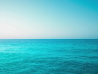 Serene ocean landscape with calm turquoise water under a clear blue sky.