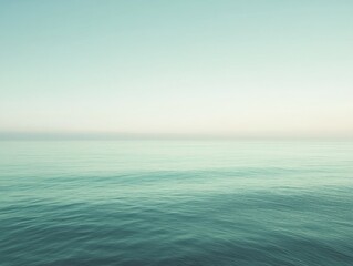 Obraz premium Serene ocean view with calm waters and a soft gradient sky.