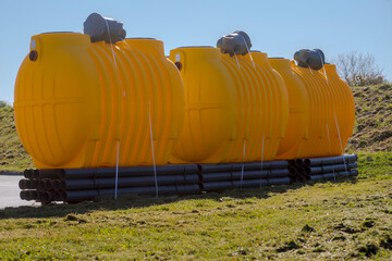 Żółte plastikowe beczki - zbiorniki (z systemem rur i studzienkami) przydomowych oczyszczalni ścieków. Zestawy rur i zbiorników (w radosnych kolorach) do systemu małych przydomowych oczyszczalni . © Grzegorz