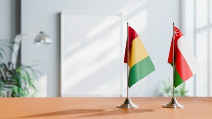 FLAGS OF GUINEA And OMAN ON TABLE