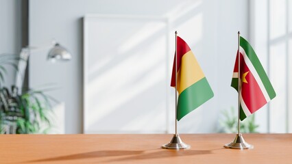 FLAGS OF GUINEA And SURINAME ON TABLE