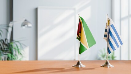 FLAGS OF GUYANA And URUGUAY ON TABLE