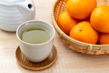 テーブルに置かれたミカンと緑茶