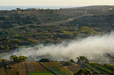 Smoke Drift Over Countryside Fields and Hills