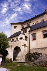 Photograph of the castle building. Historical building, castle. Castle complex, sky with clouds. Facade, arch, windows. Sights, travel, tourist spot.