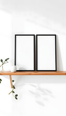 Artistic mockups template. Two black vertical picture frames on bamboo wooden shelf. White wall background. Posters at home, minimal Scandinavian design, no people. Elegant apartment concept isolate