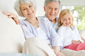 Fototapeta premium Senior man, woman and child in portrait with grandparents, happiness and bonding in family home. Elderly people, girl and together for care in living room, house or lounge for growth, support or love