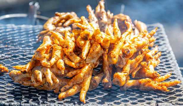 Gegrillte H&uuml;hnerf&uuml;&szlig;e auf einem Holzkohlegrill im Township Langa bei Kapstadt