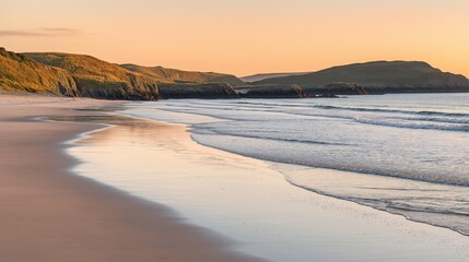 As the sun sets on the horizon, warm golden hues illuminate the tranquil waves gently lapping the sandy shore. The peaceful ambiance invites a moment of serene reflection.