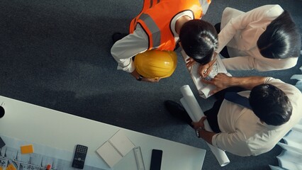 Top down view of project manager and civil engineer hold laptop while explain idea to architect....