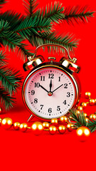 gold alarm clock with ornaments evergreen branches on a red background