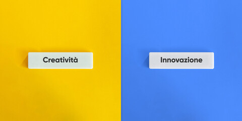 Creativity versus Innovation Words and Concept Image. Text on Block Letter Tiles on Yellow and Blue Background. Minimal Aesthetic.