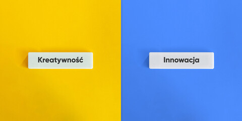 Creativity versus Innovation Words and Concept Image. Text on Block Letter Tiles on Yellow and Blue...