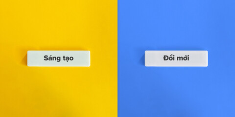 Creativity versus Innovation Words and Concept Image. Text on Block Letter Tiles on Yellow and Blue...