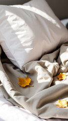 golden leaves adorn a white pillow beige blanket