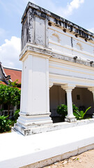 weathered white building with ornate trim